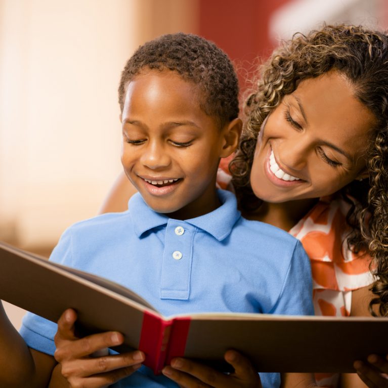 Reading with mom! African descent mother, child and book. Home.